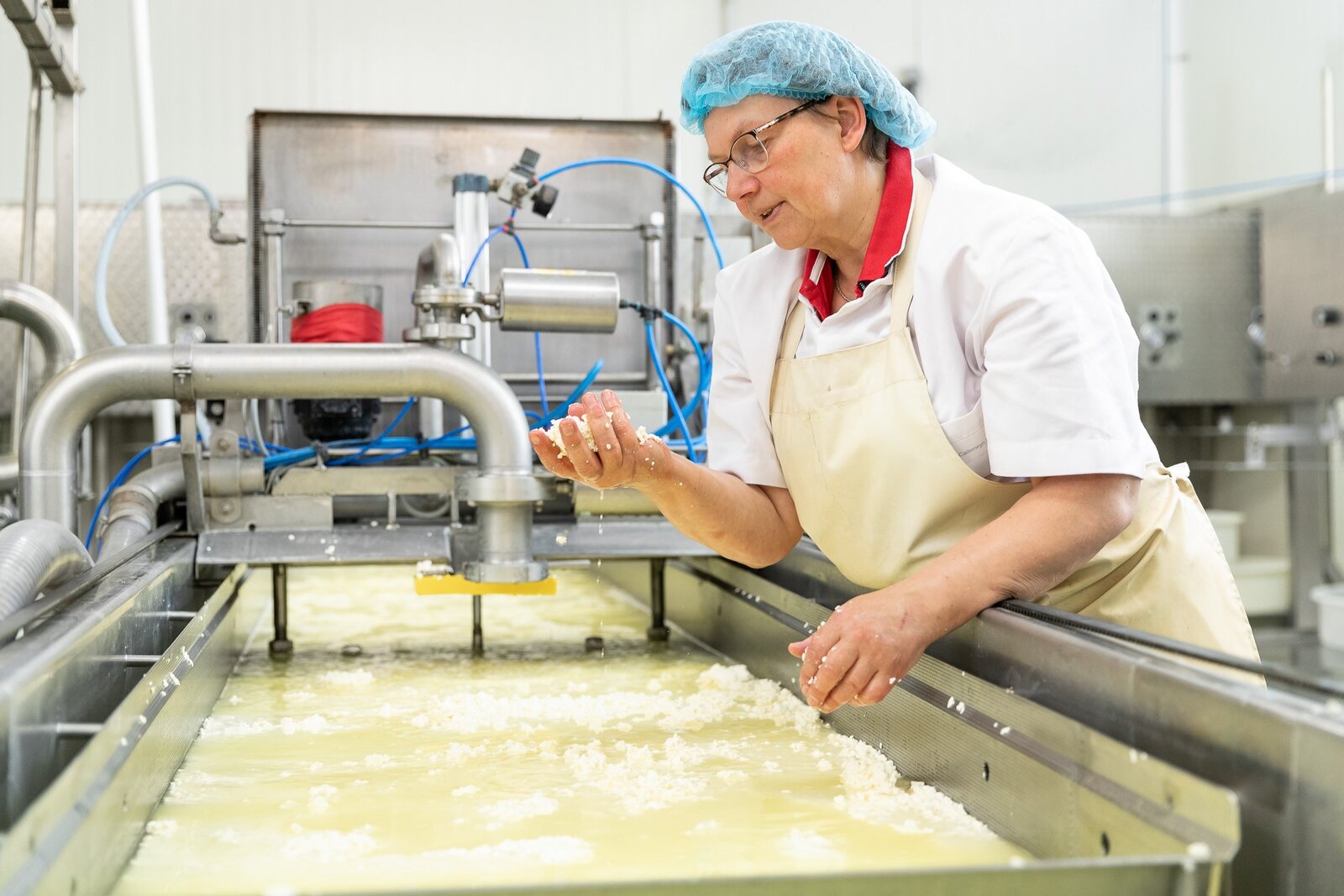 Een medewerker van Baliehof aan het werk in de kaasmakerij